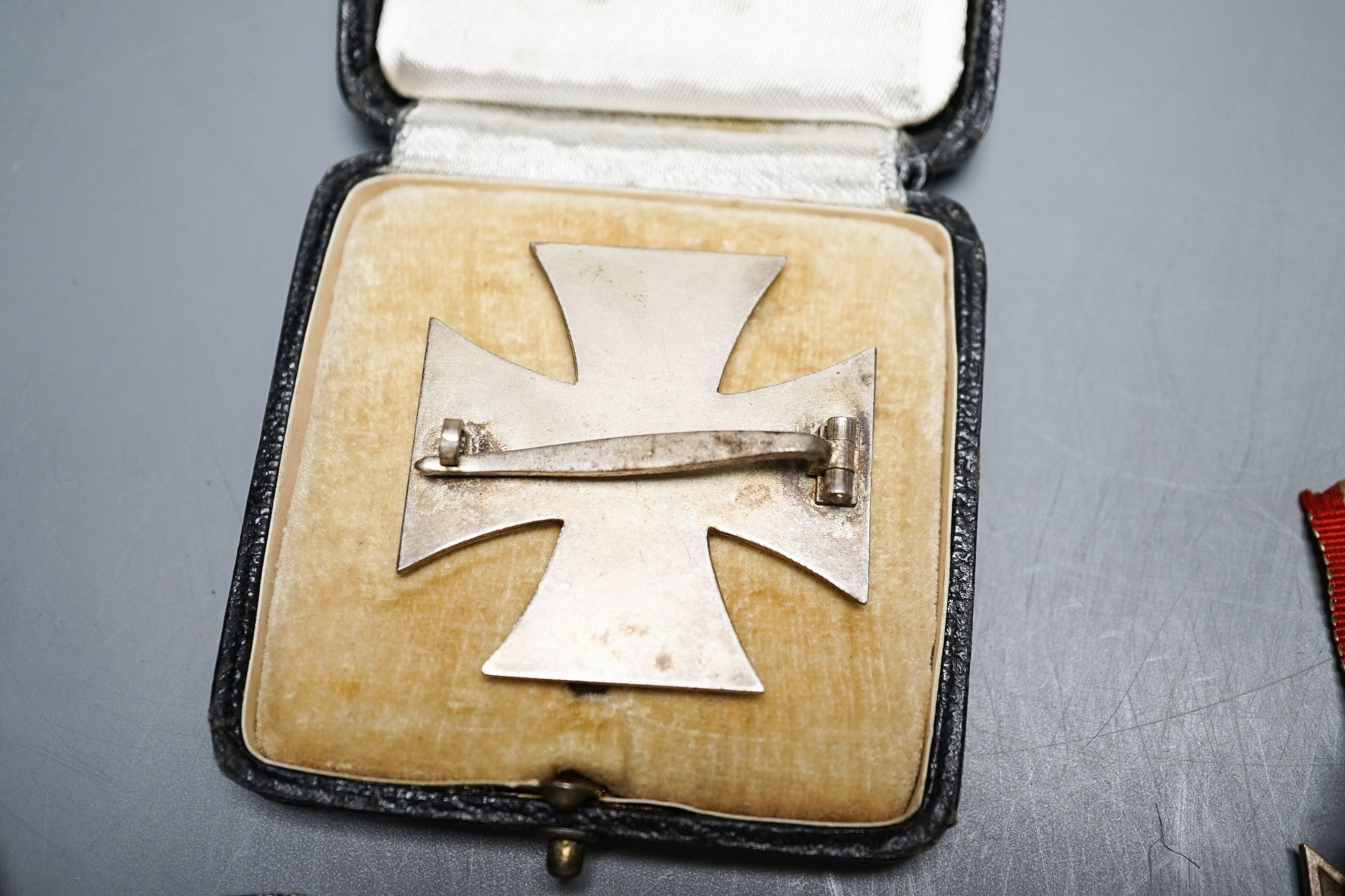 WWII Third Reich medals to include a Cross of Honour of the German Mother in gilt, another damaged in bronze, War Merit Cross (without swords), a 1939 Iron Cross and a Third Reich cuff link (5)